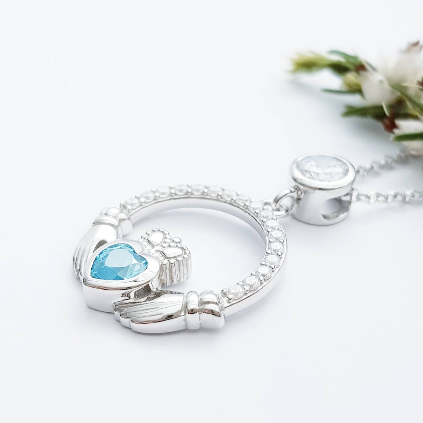 Sterling silver claddagh necklace set with electric blue December birthstone from Ireland