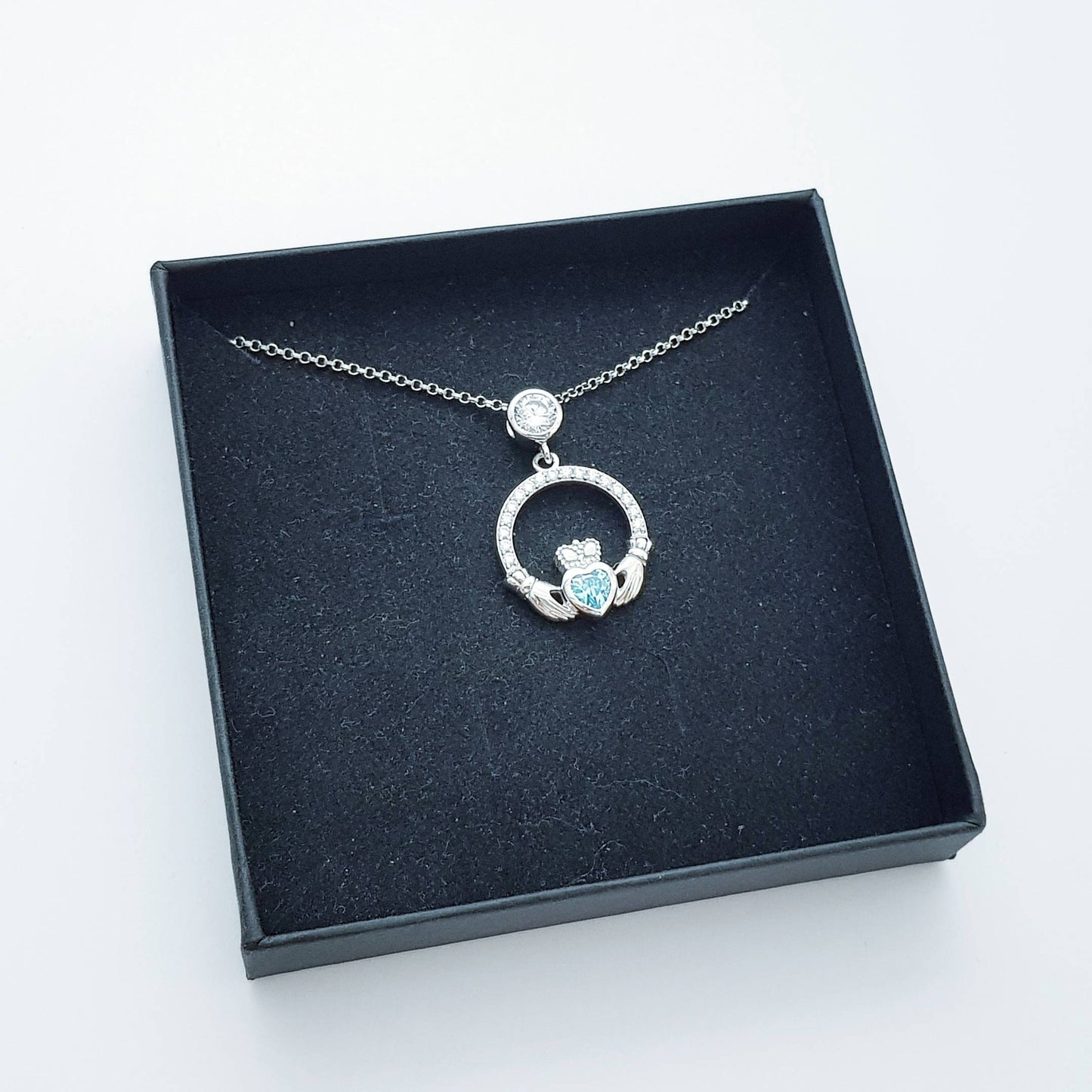 Sterling silver claddagh necklace set with electric blue December birthstone from Ireland
