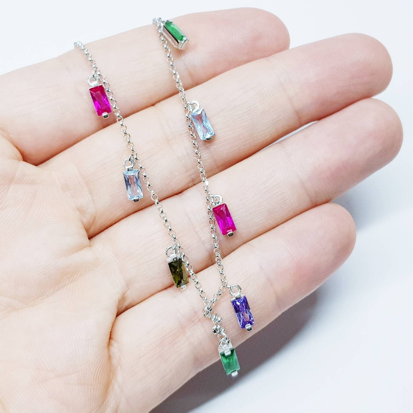 Sterling silver rainbow necklace with multi coloured stones dangling along the neckline