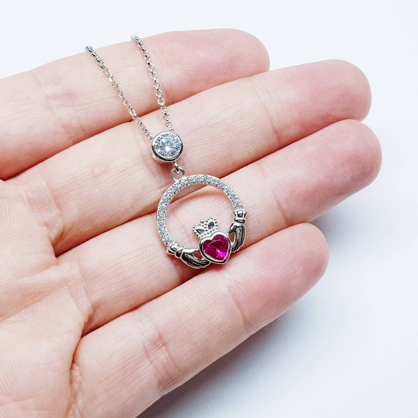 Sterling silver claddagh necklace set with ruby red July birthstone from Ireland