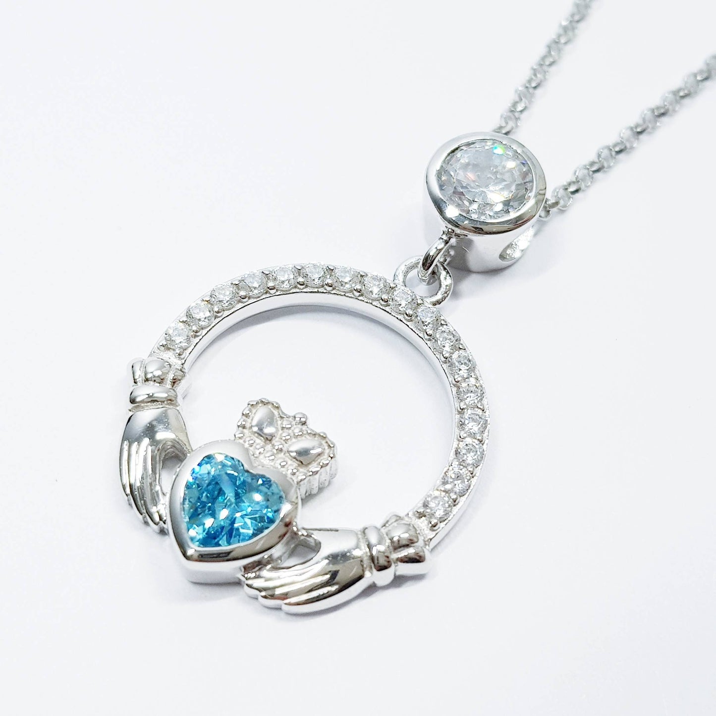 Sterling silver claddagh necklace set with electric blue December birthstone from Ireland