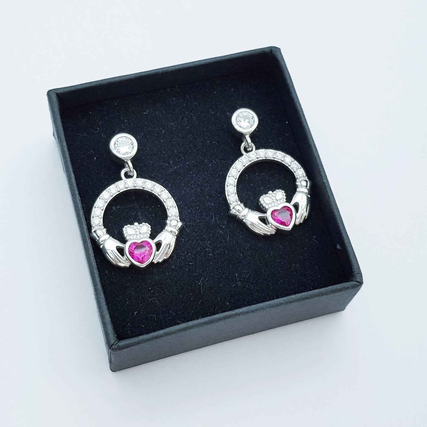 Silver claddagh drop earrings with red stone heart, July birthstone