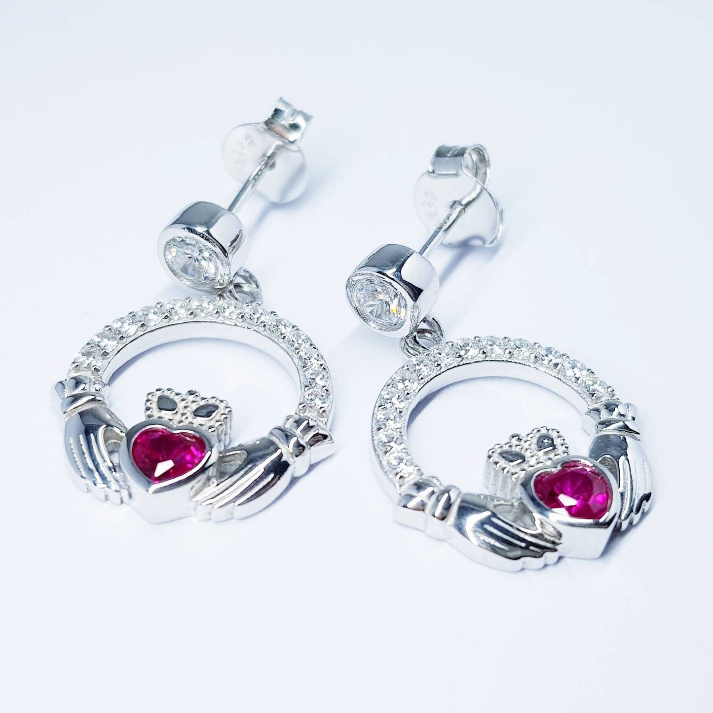 Silver claddagh drop earrings with red stone heart, July birthstone