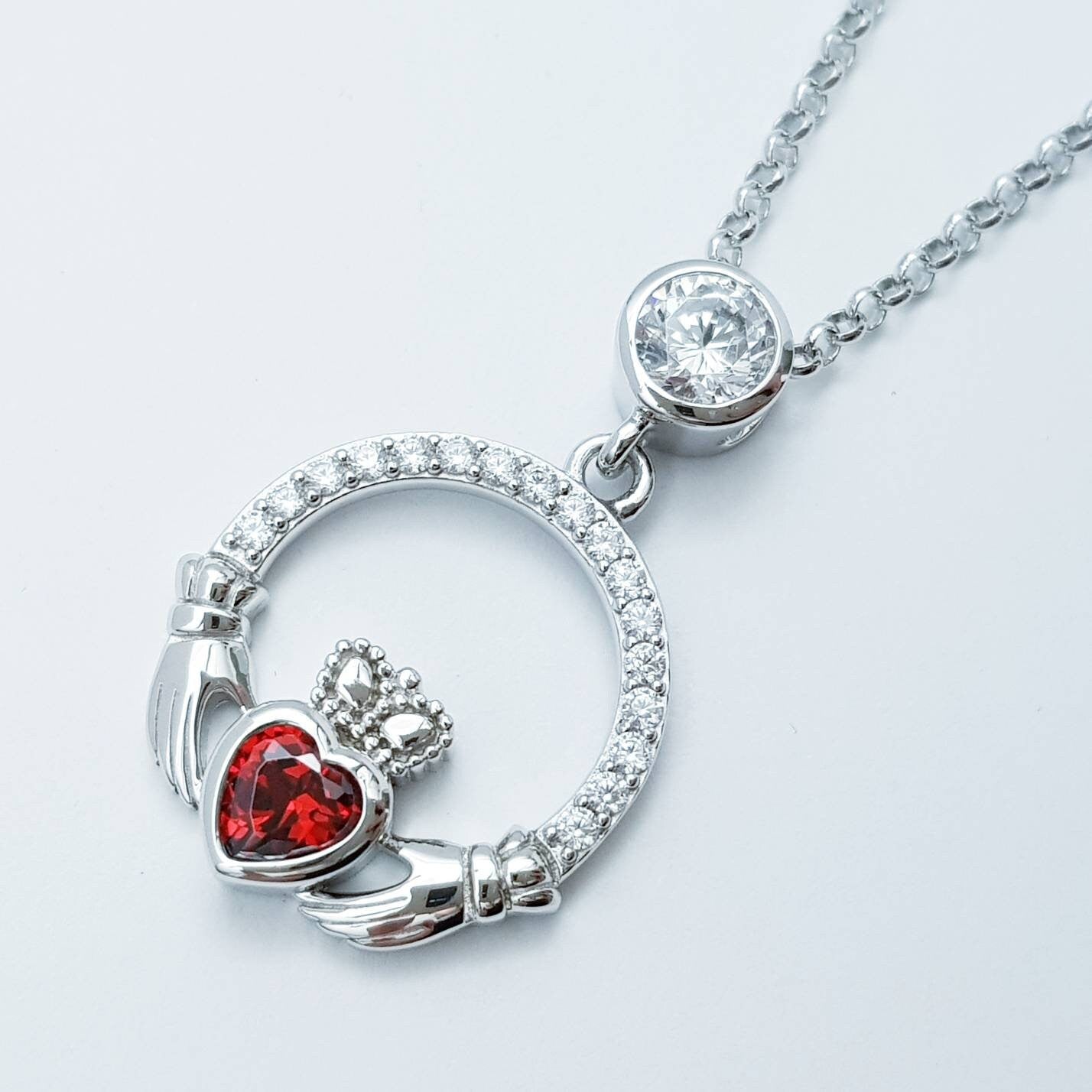 Sterling silver claddagh necklace with red garnet heart shaped stone, January birthstone