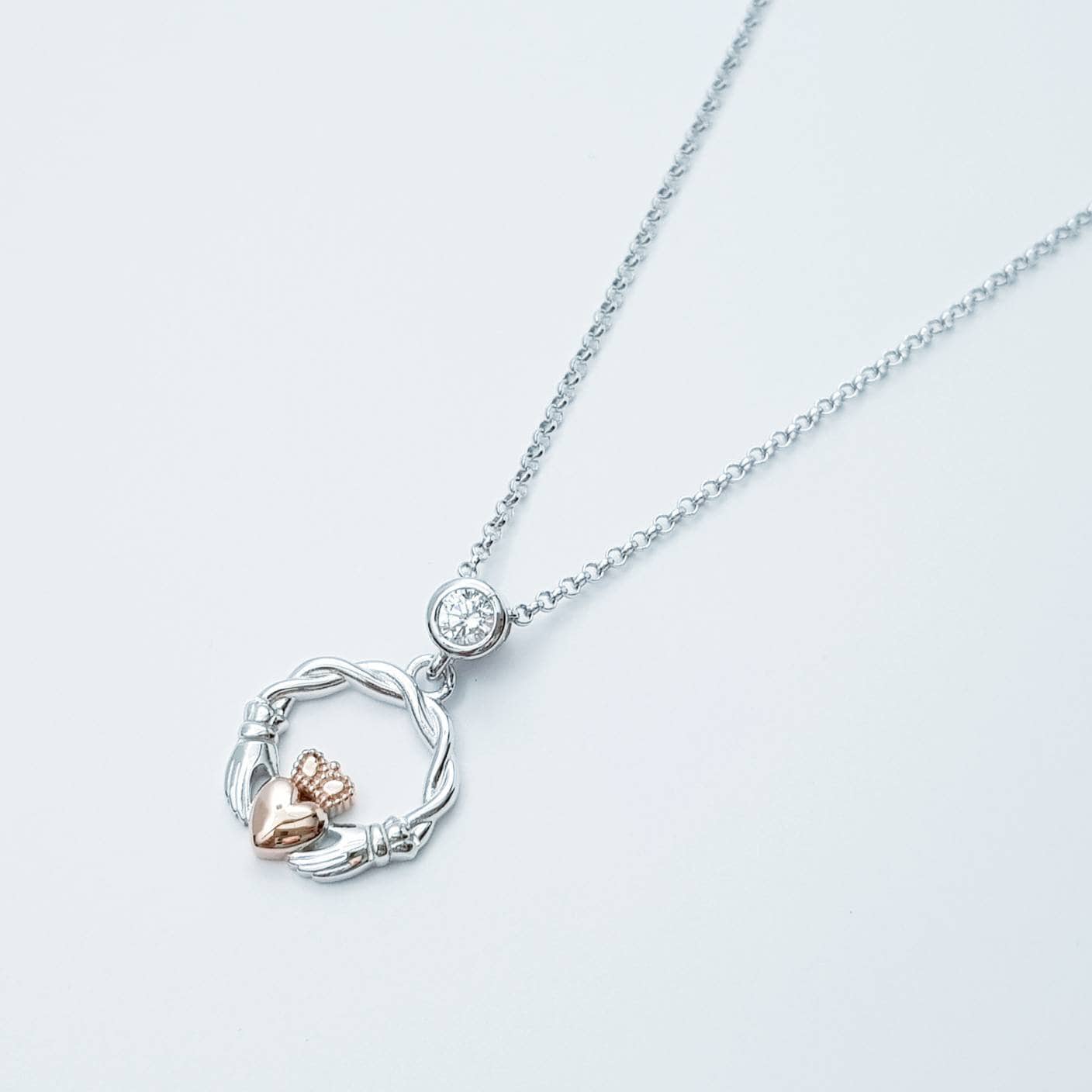 Dainty Sterling Silver claddagh necklace with rose gold plating and intertwined celtic braid.