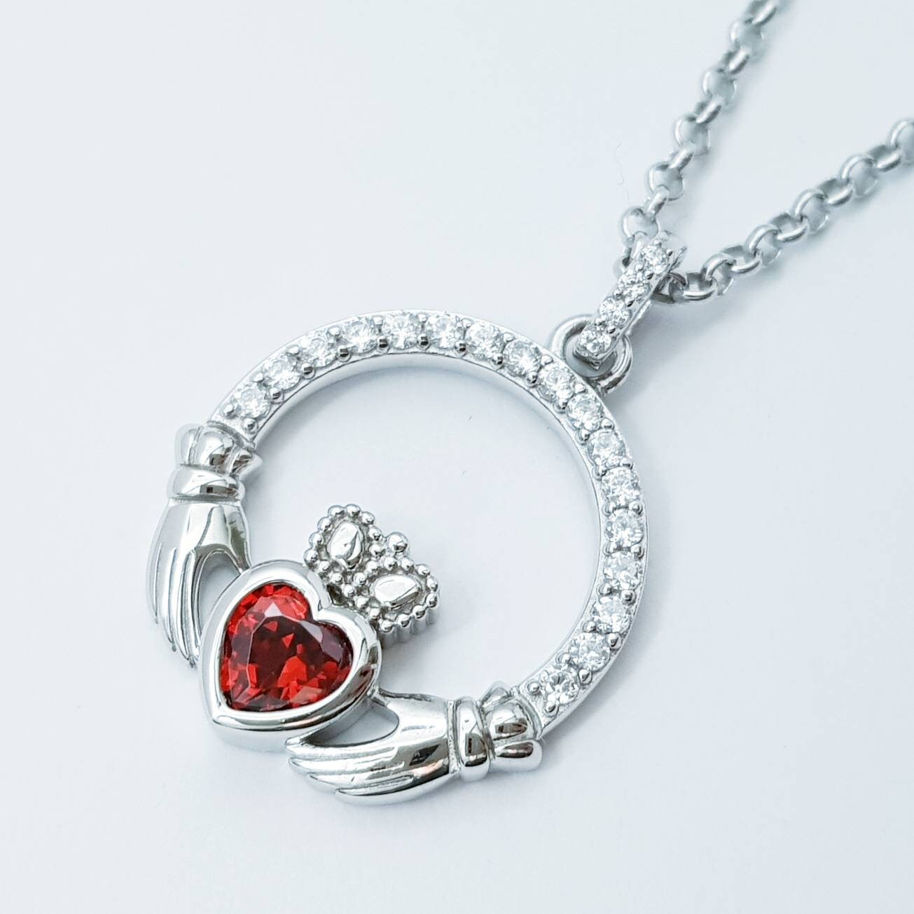 Sterling silver claddagh necklace with red garnet heart shaped stone, January birthstone