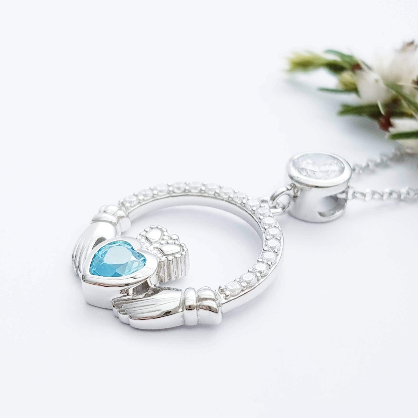 Sterling silver claddagh necklace set with electric blue December birthstone from Ireland