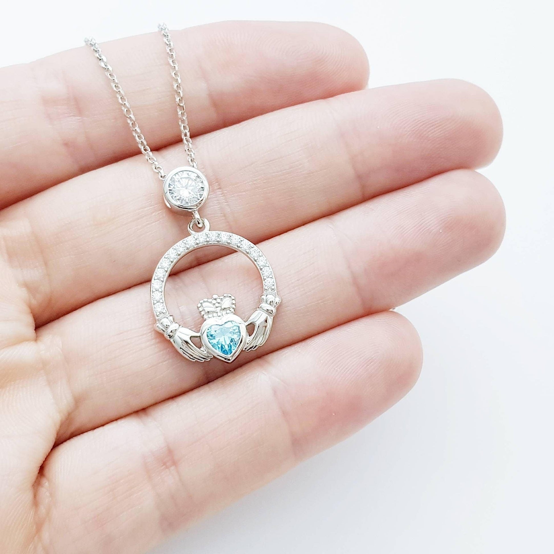 Sterling silver claddagh necklace set with electric blue December birthstone from Ireland