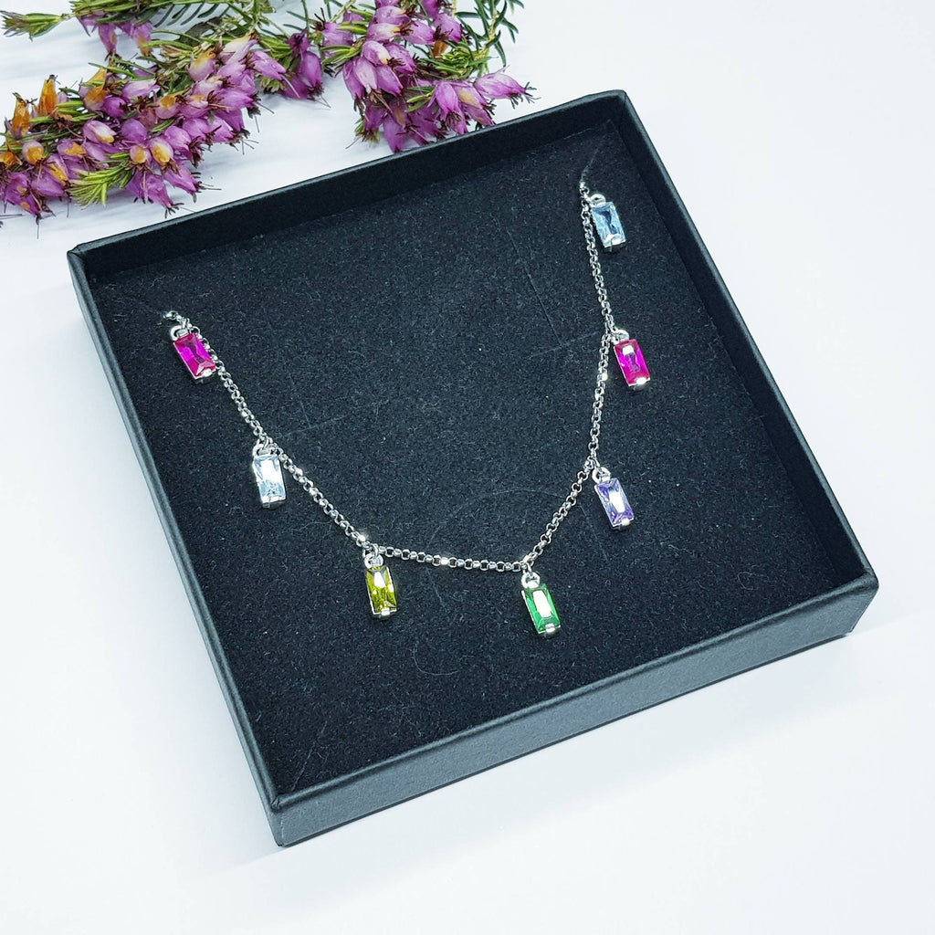 Sterling silver rainbow necklace with multi coloured stones dangling along the neckline