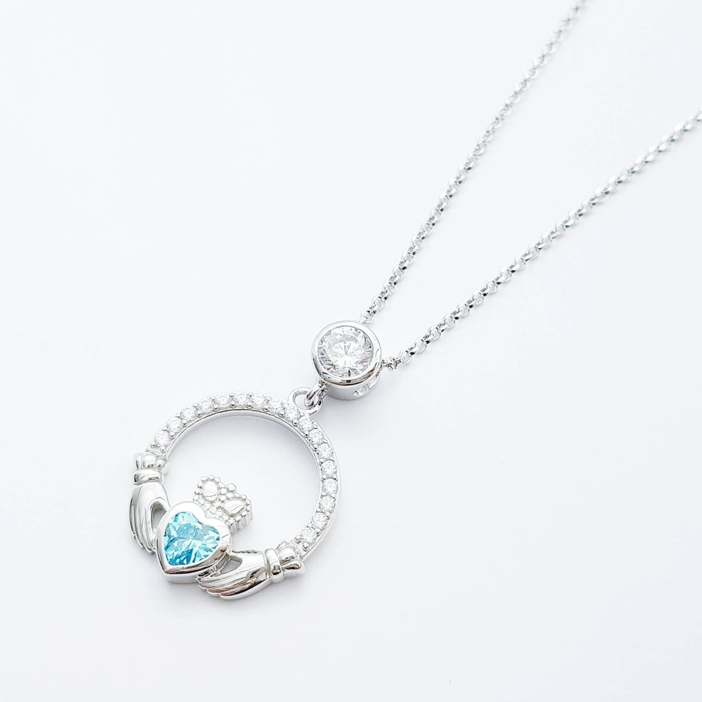 Sterling silver claddagh necklace set with electric blue December birthstone from Ireland