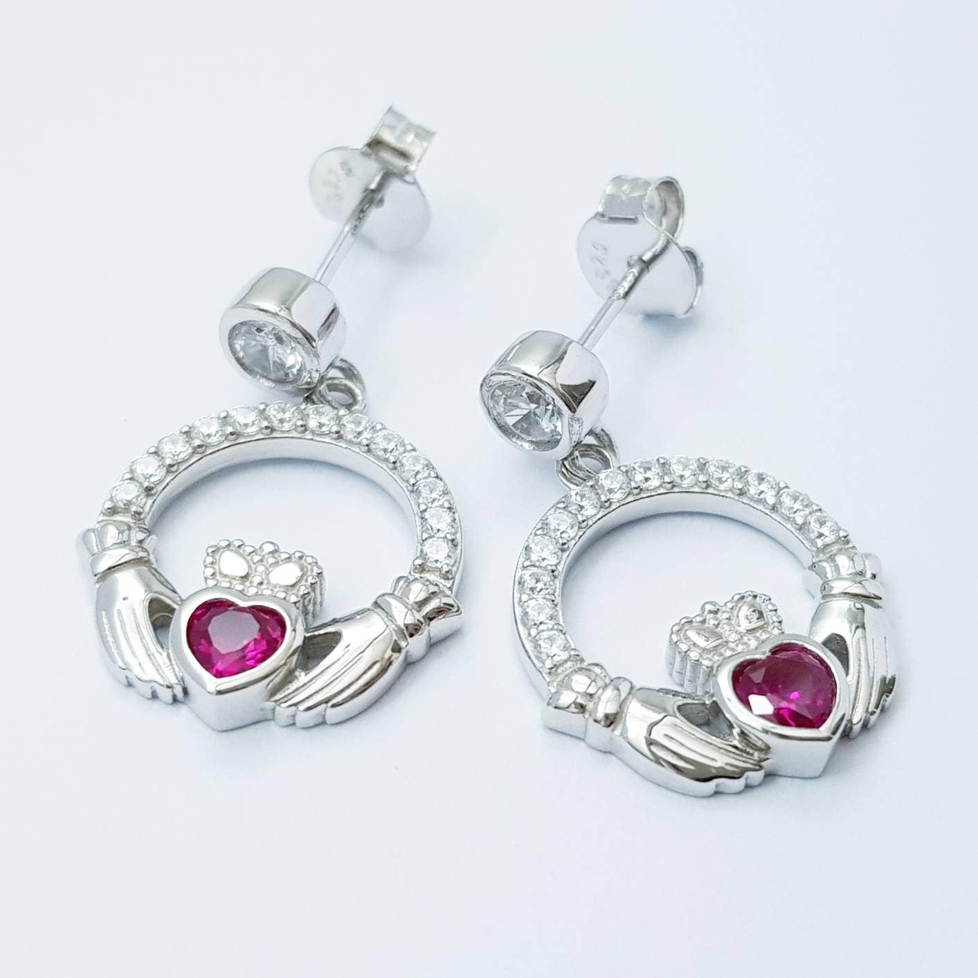Silver claddagh drop earrings with red stone heart, July birthstone