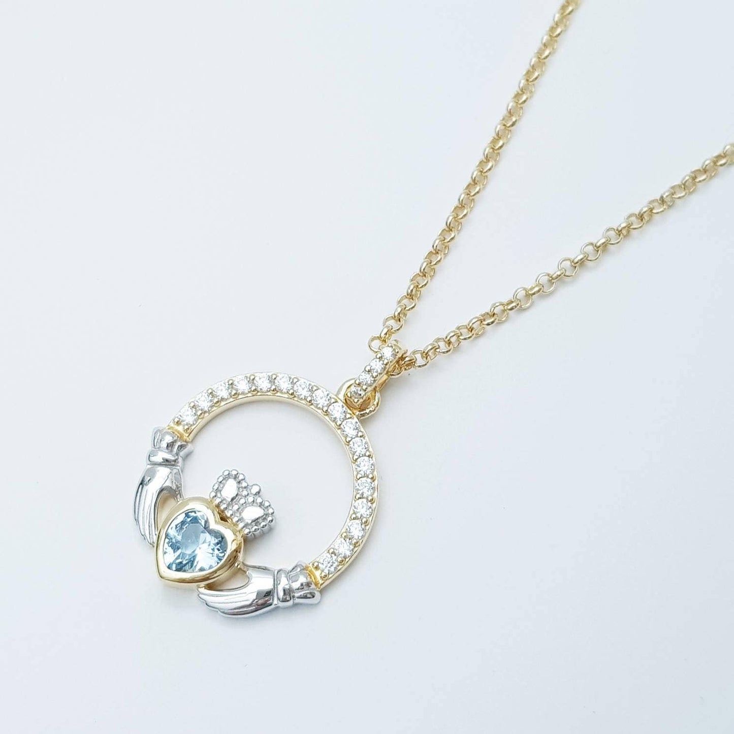 Silver and gold claddagh pendant with Aquamarine blue stone